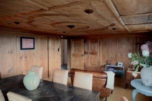 a room with a wooden ceiling with a table and chairs at Ferienwohnung Obstgarten in Märstetten