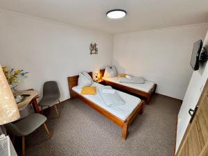 a room with two beds and a table and chairs at Villa Slnecnica in Nová Lesná