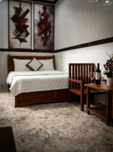 a bedroom with a bed and a table with a bottle of wine at CT Morning Hotel in Can Tho
