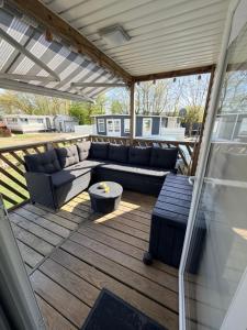 a patio with couches and a table on a deck at Strand chalet Makkum in Makkum