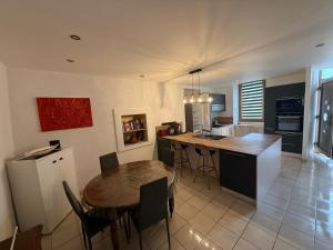a kitchen with a table and a dining room at Appartement moderne avec jardin, quartier calme in Saint-Claude