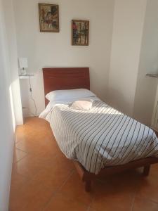 a bedroom with a bed with a striped comforter at Casa Vacanza Cascina Ronco relax nella natura vicino a Como e Bellagio in Erba