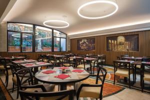 a dining room with tables and chairs and windows at Hotel Nazionale in Rome