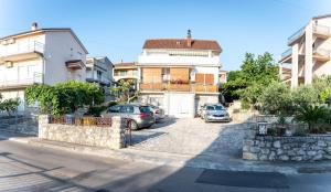 a street with cars parked in front of buildings at Apartmani Ljubica in Selce