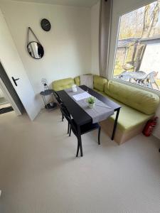 a living room with a table and a green couch at Strand chalet Makkum in Makkum
