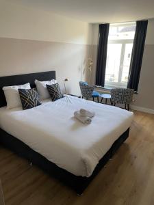 a bedroom with a large bed with a hat on it at Hotel Courage Valkenburg in Valkenburg