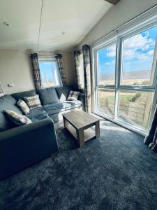 a living room with a couch and a table at SEA VIEW CARAVAN Disability friendly in Caister-on-Sea +1 photo
