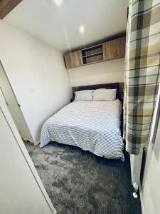 a small bedroom with a bed in a small room at SEA VIEW CARAVAN Disability friendly in Caister-on-Sea