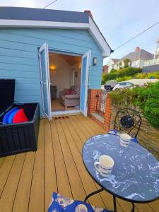 a wooden deck with a table and a patio at Downside Annexe in Woolacombe
