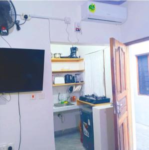 a living room with a television and a refrigerator at kandys place in Watamu