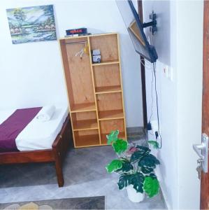 a bedroom with a bed and a potted plant at kandys place in Watamu +2 photos