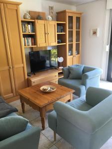 a living room with chairs and a table and a tv at Ferienhaus Familie Lehmann in Borkum
