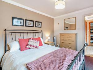 a bedroom with a large bed with red pillows at 1 Bed in Crieff oc-45288 in Saint Fillans