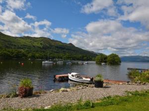 a boat is docked on a body of water at 1 Bed in Crieff oc-45288 in Saint Fillans