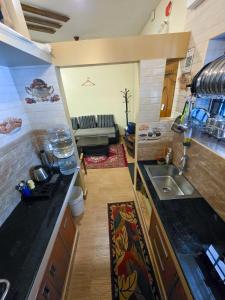 a kitchen with a sink and a couch in a room at Chithralaya Guest House in Yercaud