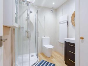a white bathroom with a shower and a toilet at 1 Bed in Ardgay oc-89058 in Culrain