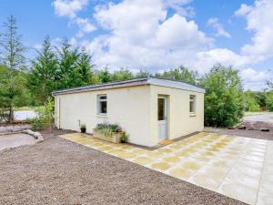 a small white building in a yard at 1 Bed in Ardgay oc-89058 in Culrain