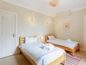 a bedroom with two beds and a door with a rug at 3 Bed in Dingwall oc-ca388 in Cononbridge