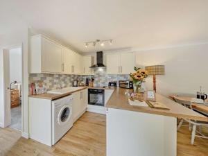 a kitchen with white cabinets and a washer at 2 Bed in Crewe oc-83192 in Audlem +12 photos