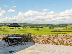 a patio with a table and chairs and a stone wall at 3 Bed in Penrith oc-89068 in Tirril