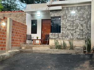 a house with a brick wall and a wooden door at Casa completa Ecovia Ruta Luque San Bernardino in Zarate Isla