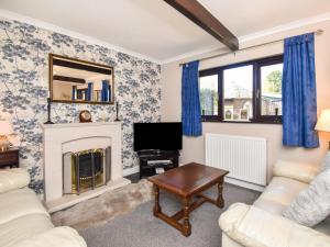 a living room with a fireplace and a tv at 3 Bed in Penrith oc-89268 in Newton Reigny