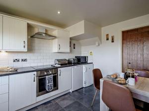 a kitchen with white cabinets and a wooden table at 2 Bed in Blackburn oc-finch in Blackburn +14 photos