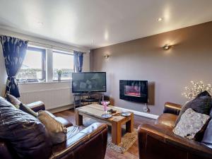 a living room with leather couches and a television at 2 Bed in Blackburn oc-finch in Blackburn