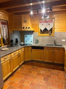 a kitchen with wooden cabinets and a sink at Le ptit Sabot in Corcieux