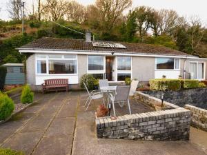 a house with a patio with a table and chairs at 2 Bed in Lochgilphead oc-ag692 in Tayvallich