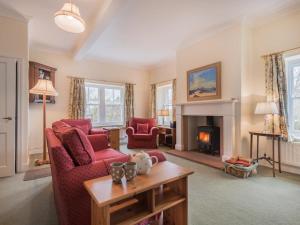 a living room with two red chairs and a fireplace at 2 Bed in Wigton oc-sz212 in Caldbeck