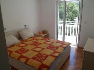 ein Schlafzimmer mit einem Bett und einer Glasschiebetür in der Unterkunft Milocer Apartment in Sveti Stefan