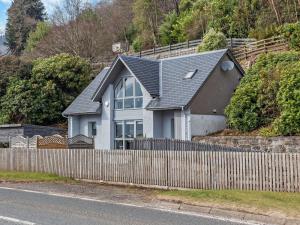 a white house with a fence in front of it at 1 Bed in Crieff oc-58797 in Saint Fillans