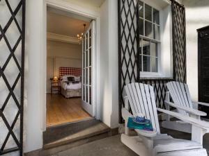 two white chairs sitting on a porch with a bedroom at 2 Bed in Grange Over Sands oc-lcc01 in Grange Over Sands