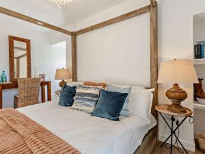 a bedroom with a bed with blue and white pillows at 4 Bed in Wick oc-95612 in Huna