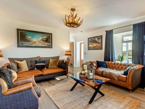 a living room with two couches and a table at 4 Bed in Wick oc-95612 in Huna