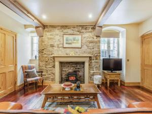 a living room with a stone fireplace and a tv at 1 Bed in Crieff oc-87497 in Crieff