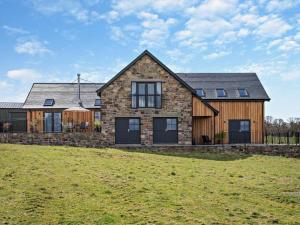 a large stone house with a grass field in front of it at 2 Bed in Auchterarder oc-94546 in Auchterarder