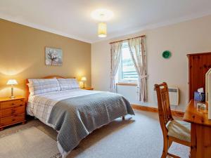 a bedroom with a bed and a desk and a window at 1 Bed in Beauly oc-82779 in Beauly