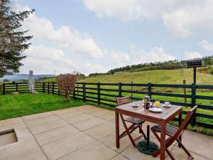 a wooden table and chairs on a patio with a fence at 1 Bed in Beauly oc-82779 in Beauly +6 photos