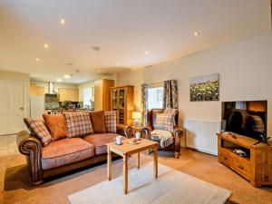a living room with a couch and a tv and a table at 2 Bed in Bonnybridge oc-90602 in Bonnybridge