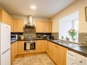 a kitchen with wooden cabinets and a sink at 2 Bed in Bonnybridge oc-90602 in Bonnybridge +9 photos
