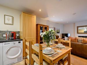 a kitchen and living room with a wooden table with flowers at 2 Bed in Bonnybridge oc-90602 in Bonnybridge