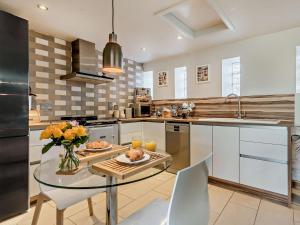 a kitchen with a table with a vase of flowers at 1 Bed in Forres oc-32129 in Burghead