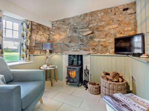 a living room with a stone wall with a wood stove at 1 Bed in Forres oc-32129 in Burghead
