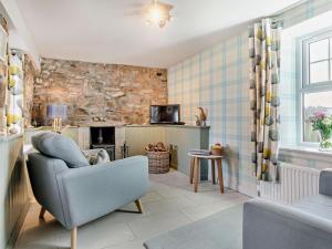 a living room with a chair and a fireplace at 1 Bed in Forres oc-32129 in Burghead +11 photos