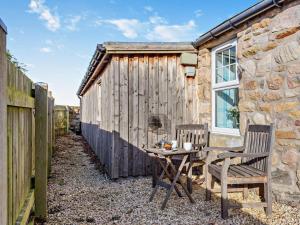 a table and two chairs in front of a building at 1 Bed in Forres oc-32129 in Burghead