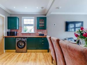 a kitchen with green cabinets and a washing machine at 2 Bed in Fort William oc-83310 in Onich +12 photos