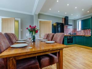 a kitchen with a wooden table with chairs and flowers at 2 Bed in Fort William oc-83310 in Onich