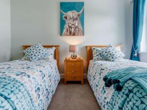 a bedroom with two beds and a picture of a cow at 2 Bed in Fort William oc-83310 in Onich